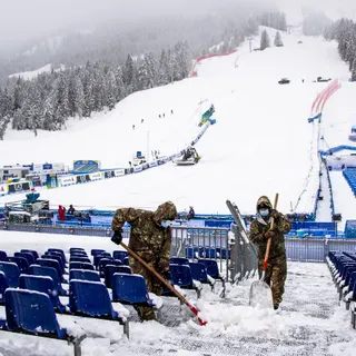 Soldados italianos limpam a neve no recinto do Campeonato de Esqui Alpino, em Cortina d'Ampezzo, Itália. FOTO JEAN-CHRISTOPHE BOTT/EPA