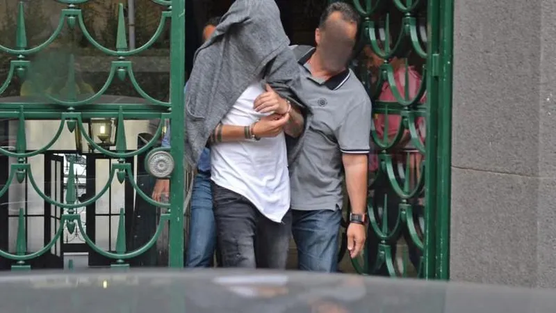 O suspeito, acompanhado por agentes da PJ, à saída do tribunal. Foto Rui Silva/ASPRESS
