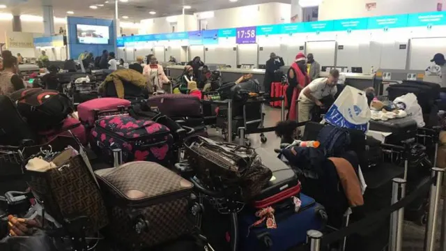 Muitos passageiros aguardam por novas indicações das companhias aéreas na zona de check-in.