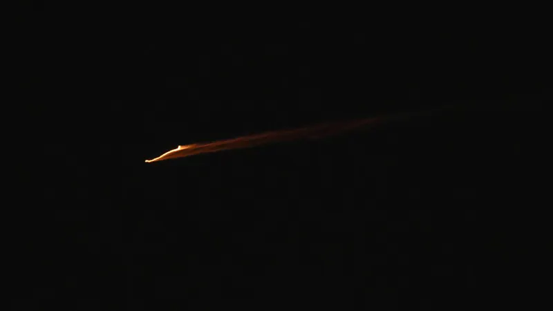 Um projéctil cruza os céus sobre a cidade de Nablus, na Cisjordânia, na noite deste domingo. As Forças Armadas de Israel relataram que sirenes de defesa aérea soaram em todo o norte e na região central do país, enquanto o sistema de defesa aérea procurava interceptar sucessivas salvas de mísseis balísticos lançados pelo Irão em direcção a Israel. FOTO ALAA BADARNEH/EPA