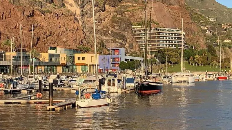 O pequeno veleiro branco está num pontão, isolado das restantes embarcações. Foto e Vídeo Vitor Hugo