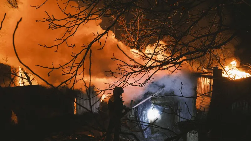 Incêndio em um edifício particular após bombardeamento russo na vila de Ivanivka, perto de Bakhmut, na área de Donetsk, Ucrânia, a 2 de Janeiro de 2023.<br>