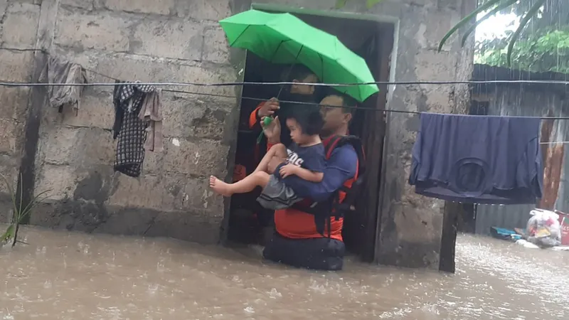 Socorristas a evacuar civis numa das áreas inundadas em Ozamiz, Filipinas, a 25 de Dezembro de 2022<br>