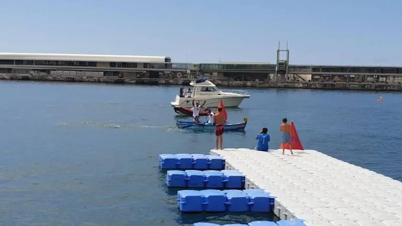 Foto da embarcação vencedora a cortar a meta.   