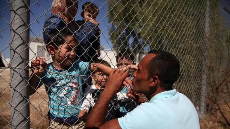 Ammar Hammasho reencontra os filhos e a mulher, que acabam de chegar a um campo de refugiados nos arredores de Nicosia, Chipre.  Foto REUTERS/Yiannis Kourtoglou