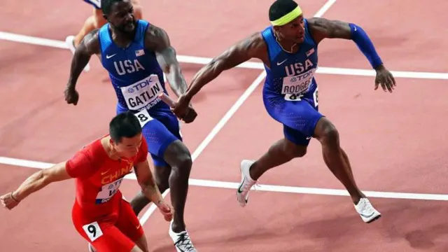 Justin Gatlin entrega a estafeta a Michael Rodgers na final de 4x100m conquistada pelos norte-americanos.  Foto EPA/ALI HAIDER
