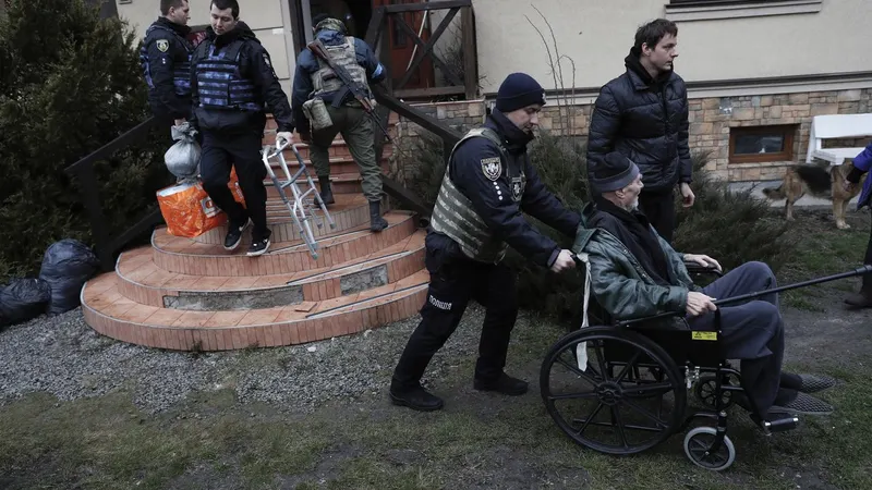 Elementos da defesa territorial ucraniana ajudam a retirar idosos de um abrigo em Irpin, uma das cidades libertadas após a retirada das tropas russas. FOTO ATEF SAFADI/EPA