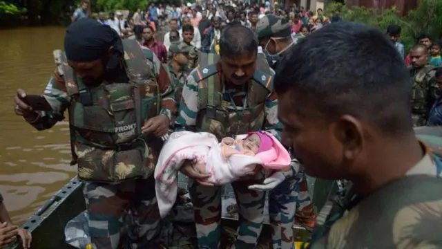 Um militar indiano segura num bebé durante as evacuações da população afectada por inundações no estado de Maharashtra, Índia